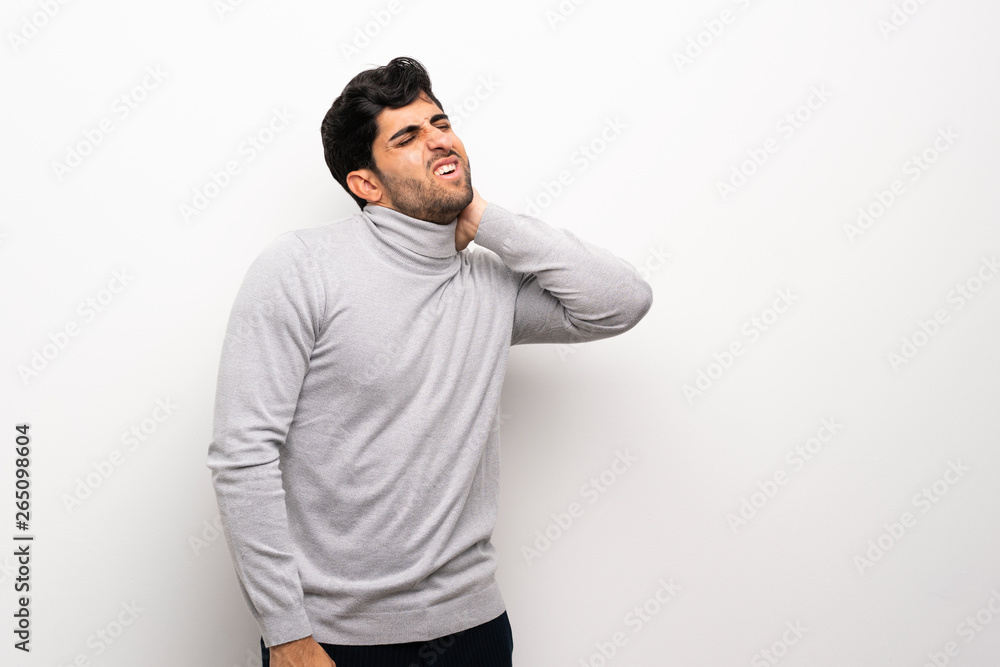 Young man over isolated white wall with neckache Young man over isolated white wall with neckache