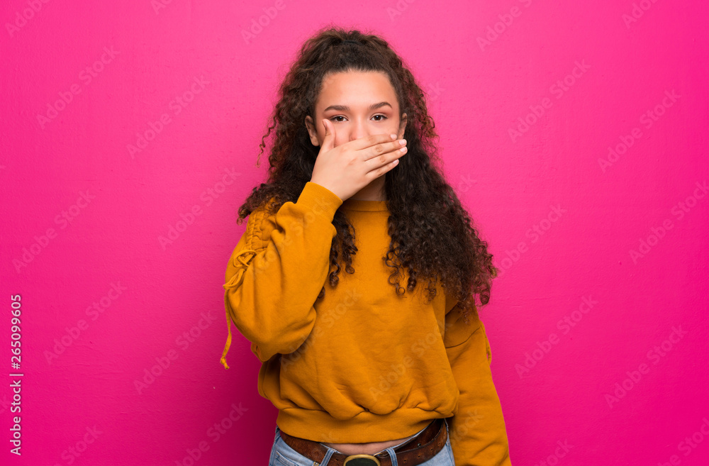 Teenager girl over pink wall covering mouth with hands Teenager girl over pink wall covering mouth with hands