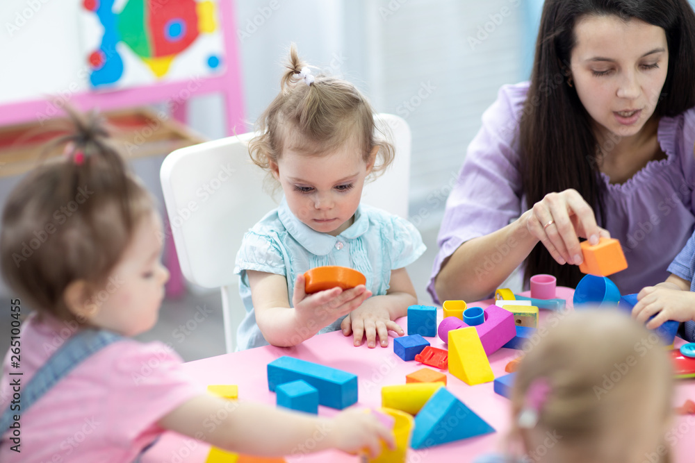 Babies in kindergarten. Kids toddlers in nursery school. Little children preschoolers play with teacher. Babies in kindergarten. Kids toddlers in nursery school. Little children preschoolers play with teacher.