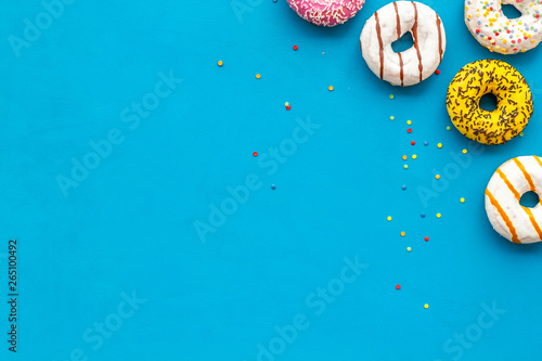 Traditional american donuts of different flavors on blue background flat lay mockup