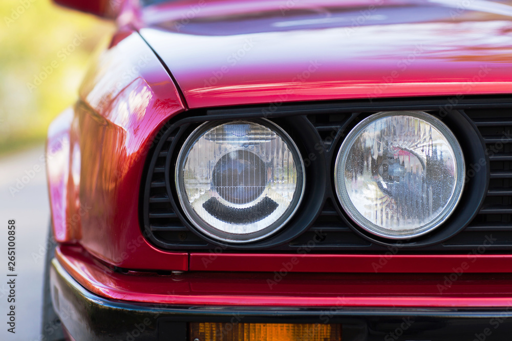 Headlights of a red, old, retro car, closeup