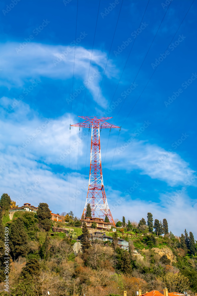 Obraz premium High voltage power lines on a hill . Electrical tower over residential buildings in Istanbul, Turkey 
