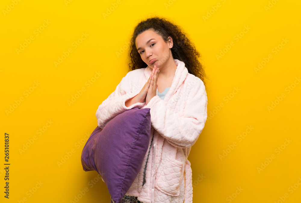 Teenager girl in pajamas keeps palm together. Person asks for something Teenager girl in pajamas keeps palm together. Person asks for something