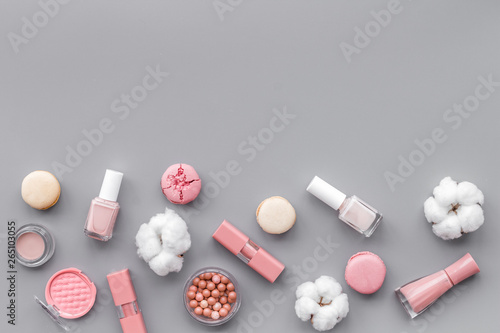 make-up accessories, fashion stylish cosmetics and macaroon on gray desk background top view copy space