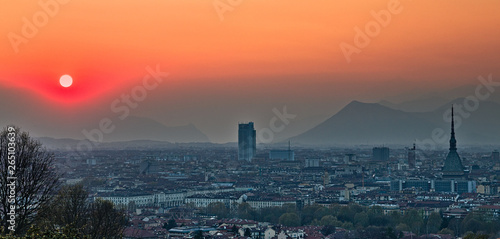 Aerial view on Torino cityscape during a sunset in a foggy spring day, sky is milky and colorful