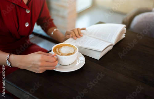 Girl having coffee in the bar and reading