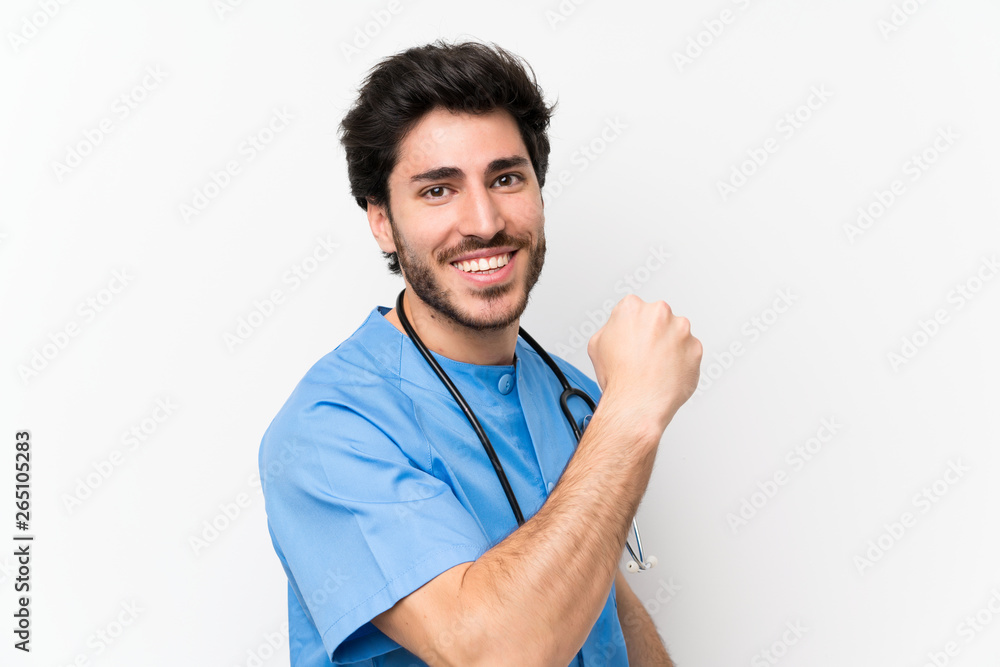 Surgeon doctor man over isolated white wall celebrating a victory Surgeon doctor man over isolated white wall celebrating a victory
