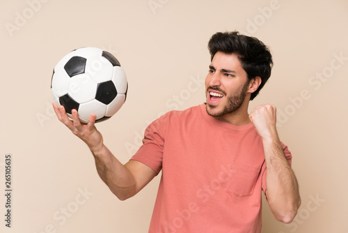 Handsome man holding a soccer ball