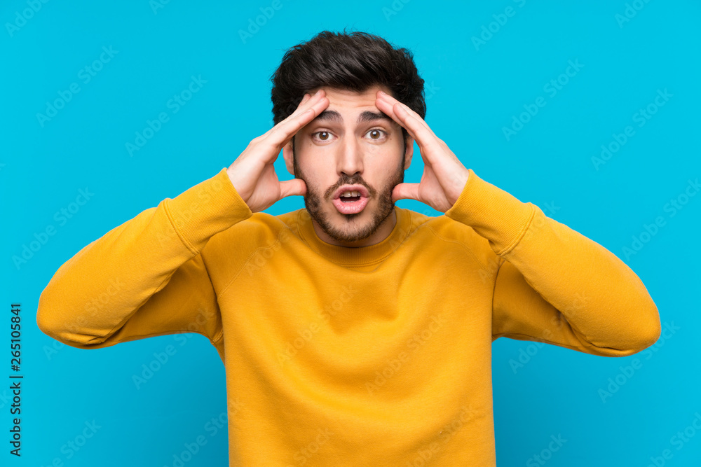 Handsome over isolated blue wall with surprise expression Handsome over isolated blue wall with surprise expression