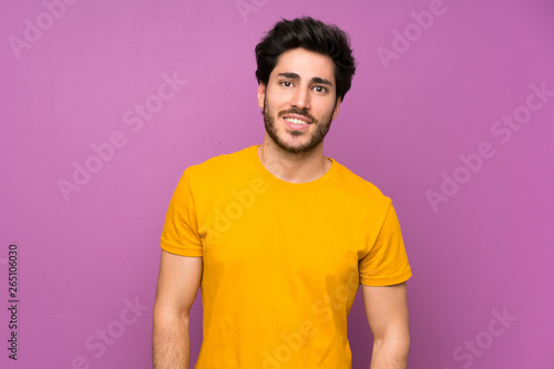 Handsome over isolated purple wall laughing