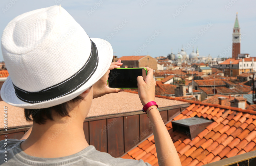 boy takes picutres with smartphone at Bell Tower of saint Mark i