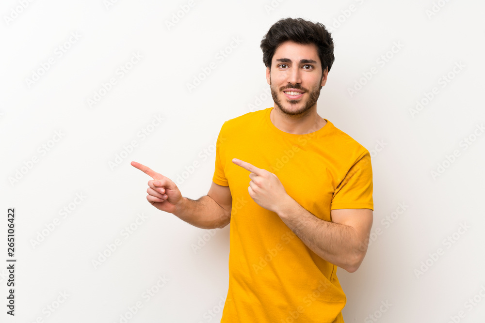 Handsome over isolated white wall pointing finger to the side Handsome over isolated white wall pointing finger to the side