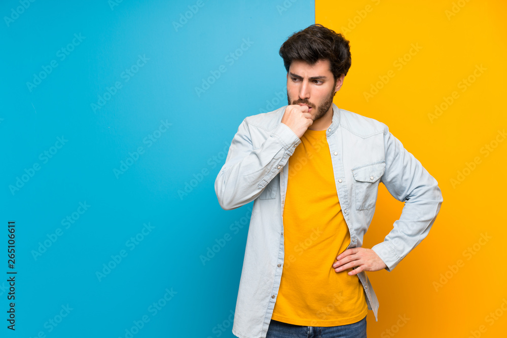 Handsome over isolated colorful background having doubts Handsome over isolated colorful background having doubts