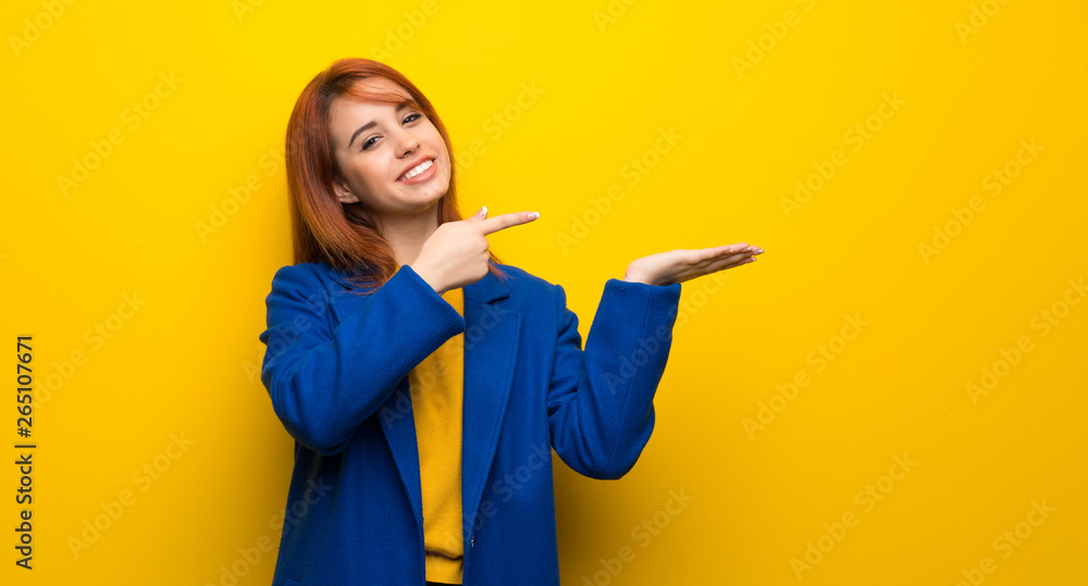 Young redhead woman with trench coat holding copyspace imaginary on the palm to insert an ad Young redhead woman with trench coat holding copyspace imaginary on the palm to insert an ad