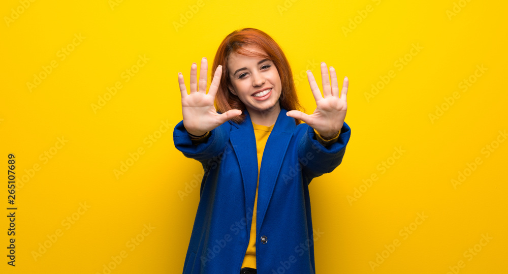 Young redhead woman with trench coat counting ten with fingers Young redhead woman with trench coat counting ten with fingers