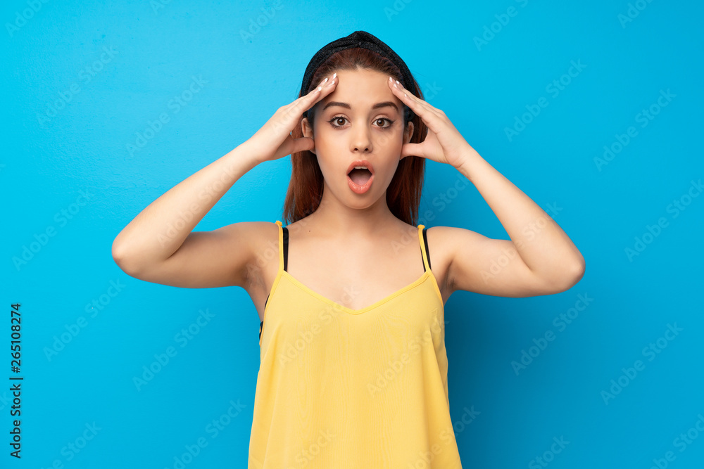 Young redhead woman over blue background with surprise expression Young redhead woman over blue background with surprise expression