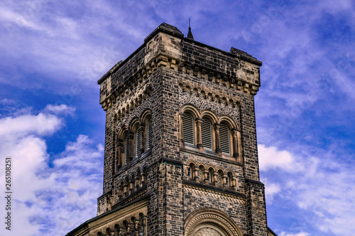 Old gothic tower in front of cloudy blue sky photo