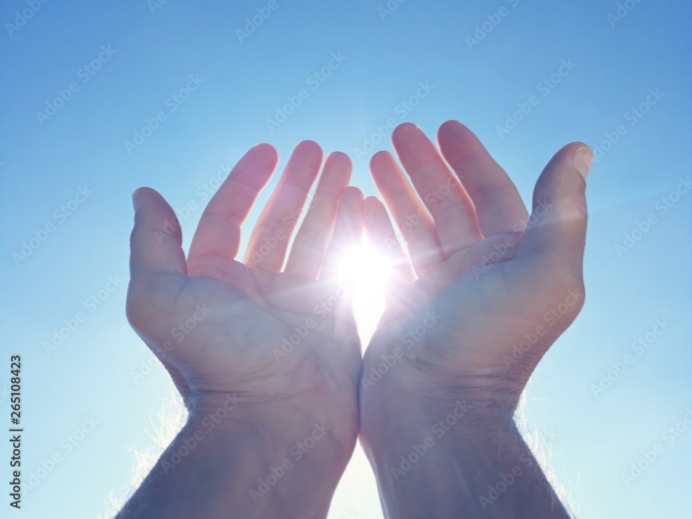 Male hands holding sun with blue sky. Male hands holding sun with blue sky.
