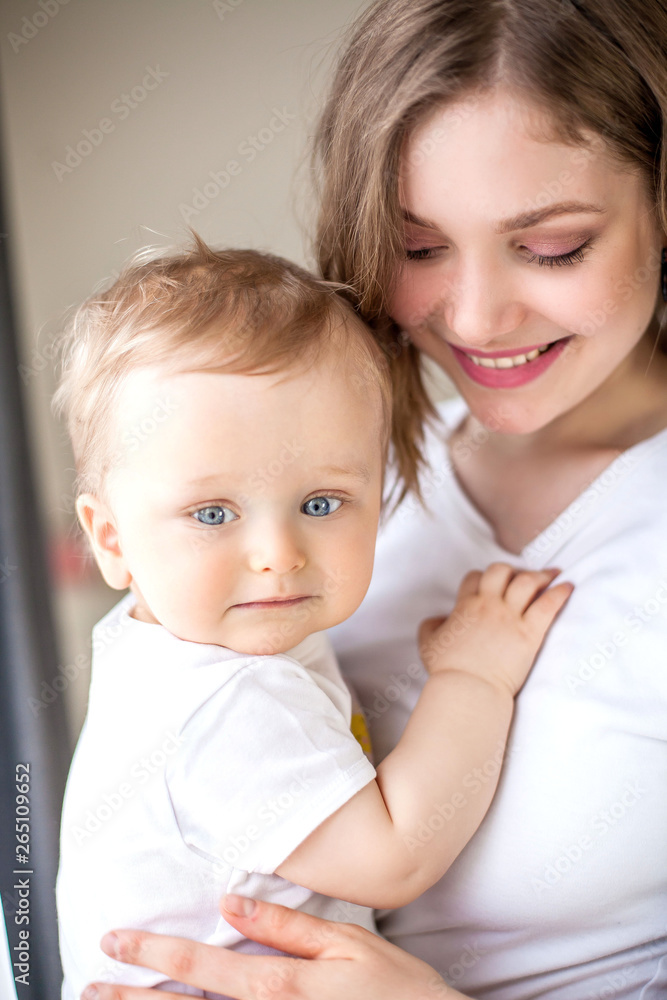 Beautiful mother and little son 9 months in the home interior. Cozy. Baby. Motherhood. Beautiful mother and little son 9 months in the home interior. Cozy. Baby. Motherhood.