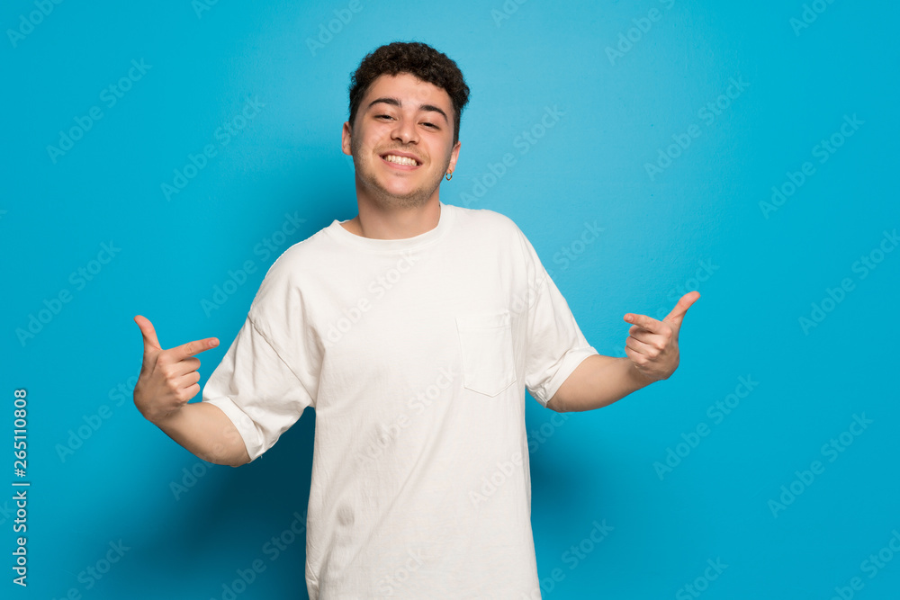 Young man over blue background proud and self-satisfied in love yourself concept Young man over blue background proud and self-satisfied in love yourself concept
