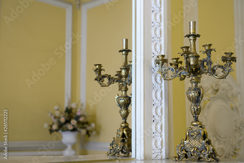 Antique candelabrum on mirror in the room. An ancient candlestick in the interior. 