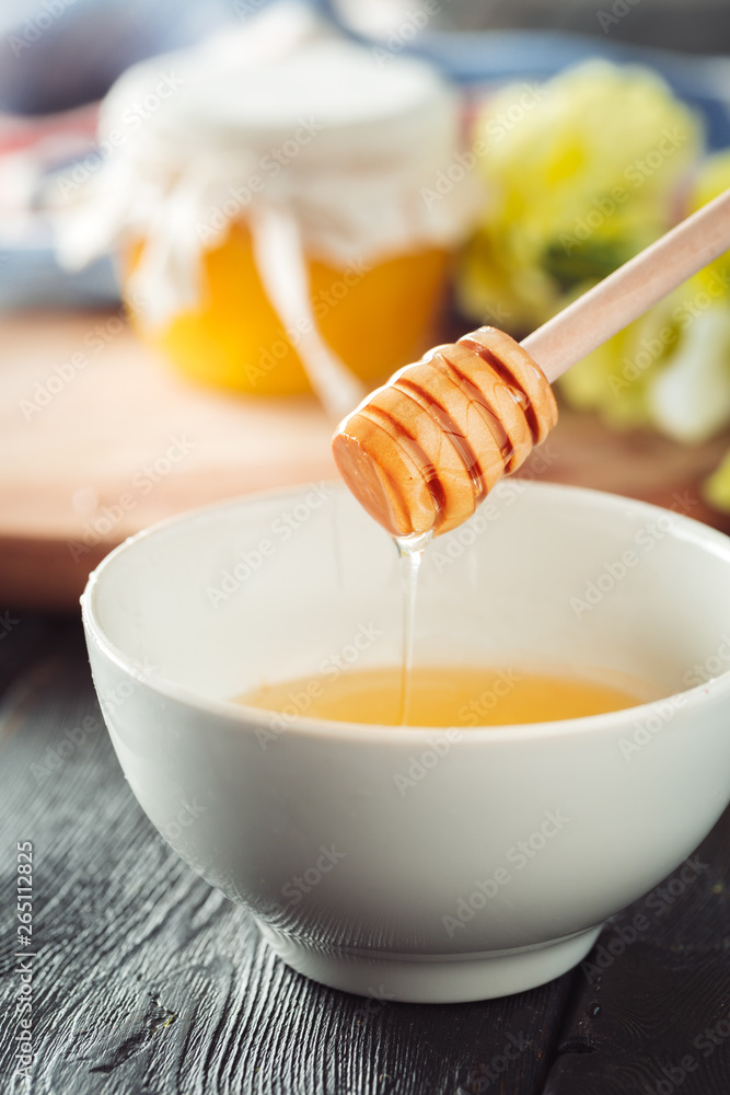 Honey background. Sweet honey in glass jar on wooden background. Honey background. Sweet honey in glass jar on wooden background.