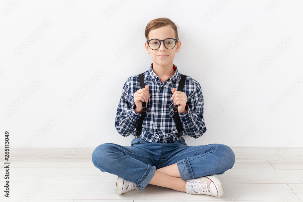 teenager, children and fashion concept - Fashionable boy sitting on floor over white background teenager, children and fashion concept - Fashionable boy sitting on floor over white background