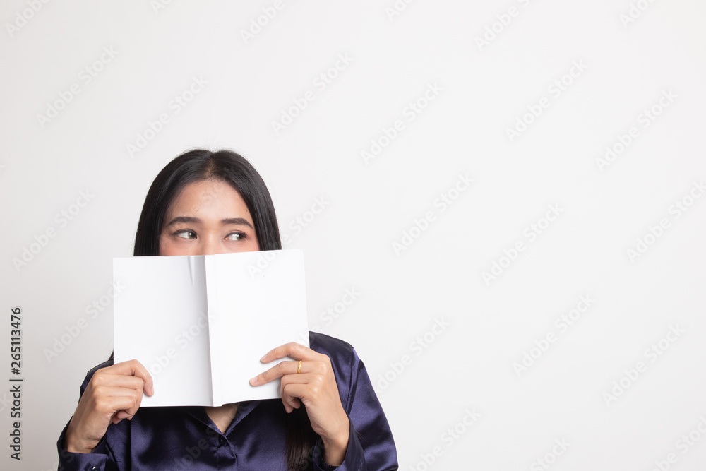 Young Asian woman with a book cover her face. Young Asian woman with a book cover her face.