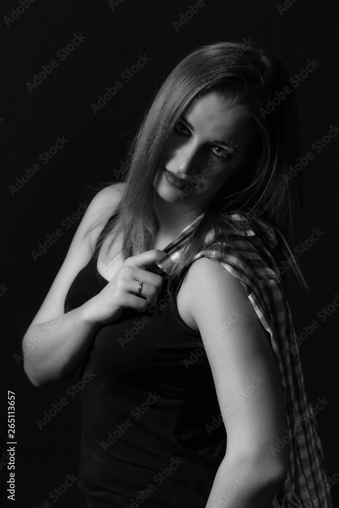 Low key monochrome portrait of beautiful young woman posing.