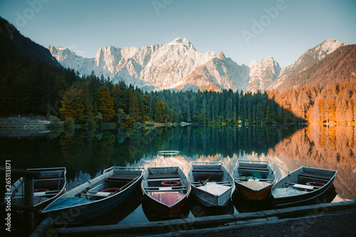 Beautiful morning scene with boats in mountain lake at sunrise photo