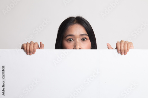 Close up of young Asian woman behind a blank sign.