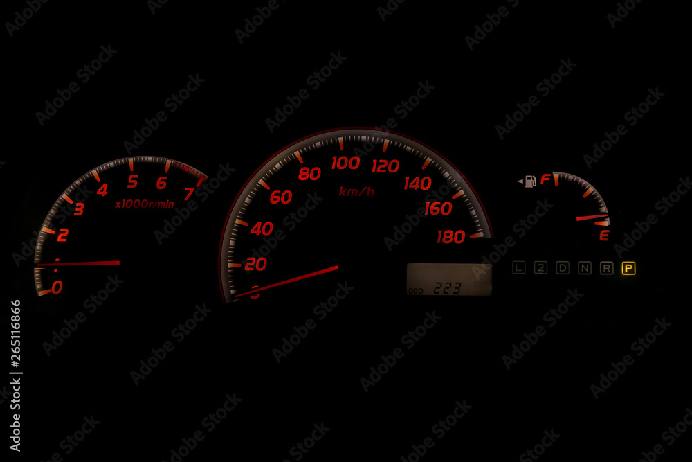 The dashboard of the car is glowing white with orange arrows at night with a speedometer, tachometer and other tools to monitor the condition of the vehicle in classic style