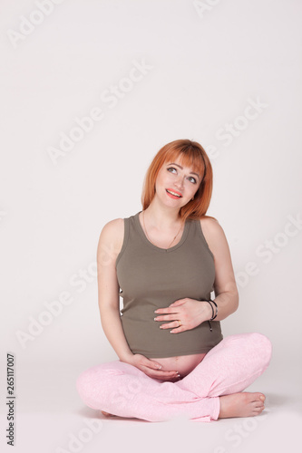 Happy pregnant woman is looking at something. Perinatal medicine. Maternal and fetal health. Empty place for inscription. photo