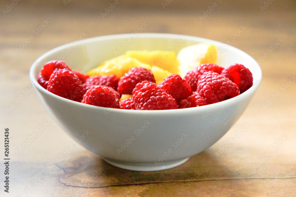 Ananasstücke und Himbeeren in einer Schale Ananasstücke und Himbeeren in einer Schale