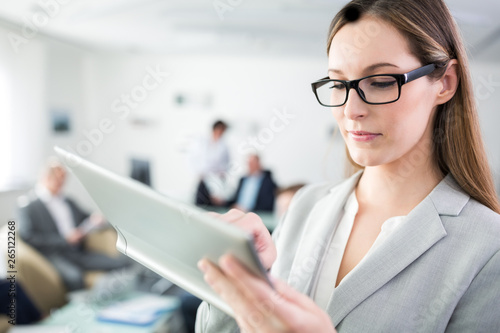 Geschäftsfrau mit Brille bedient Tablet Computer