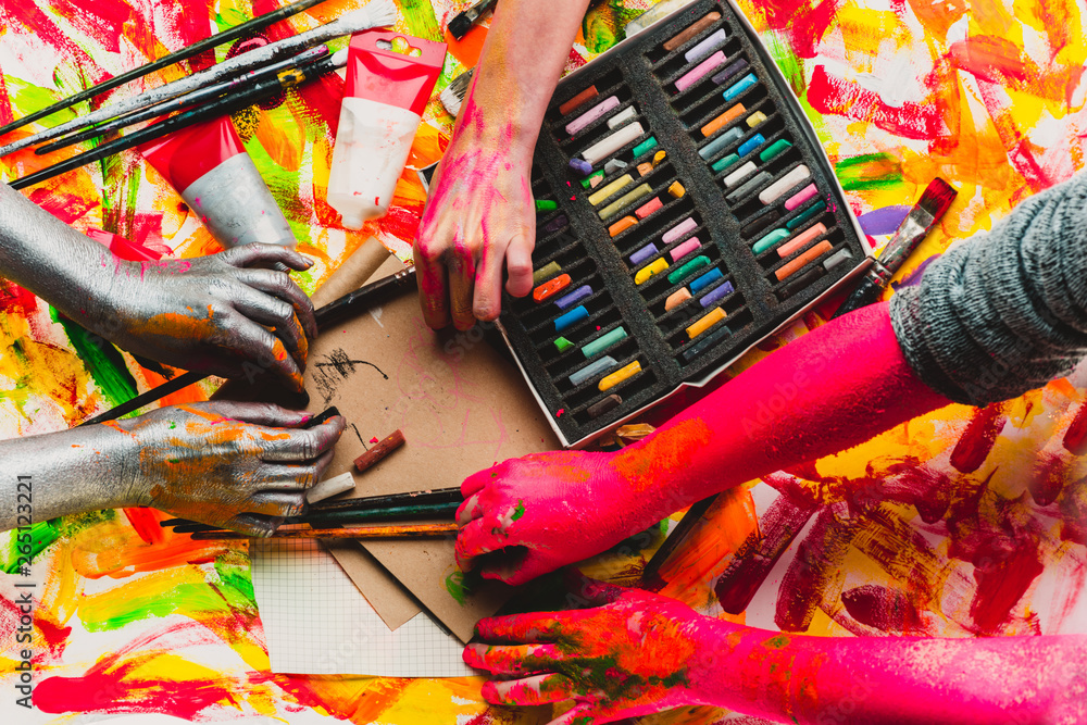Teamwork. Draw a picture together. Fun as a collective art therapy. Multicolored hands and pastel pencils. Stationery store. Shop for Artists. Hands and creativity Teamwork. Draw a picture together. Fun as a collective art therapy. Multicolored hands and pastel pencils. Stationery store. Shop for Artists. Hands and creativity