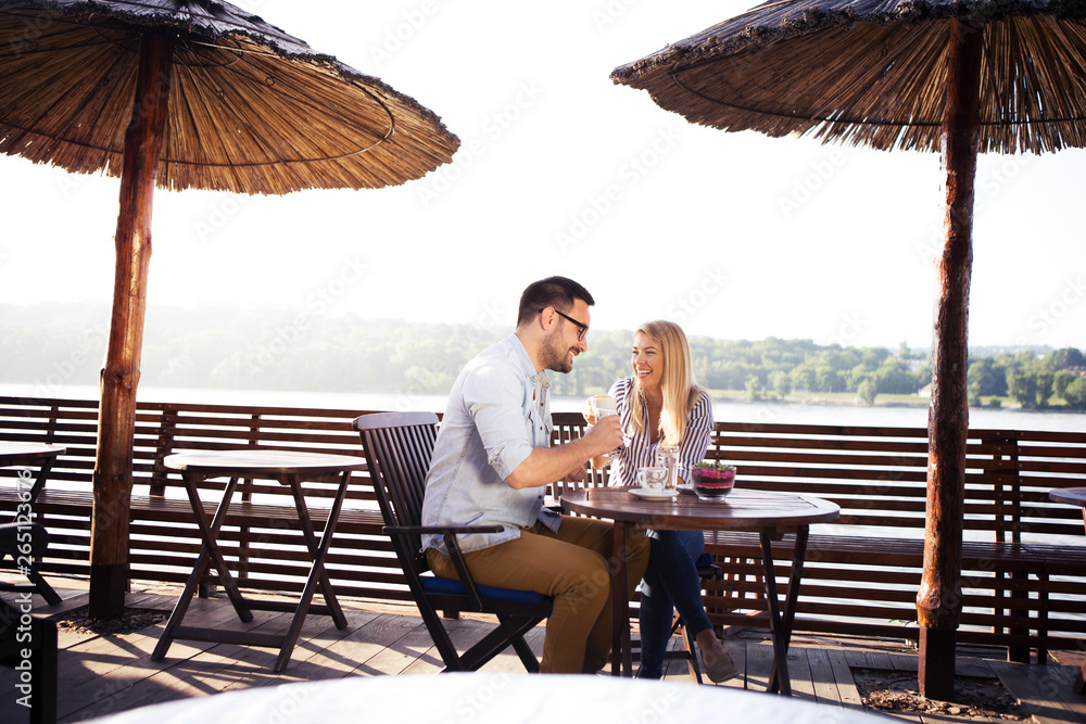 A loving young couple spends very nice moments in a cafe by the river.