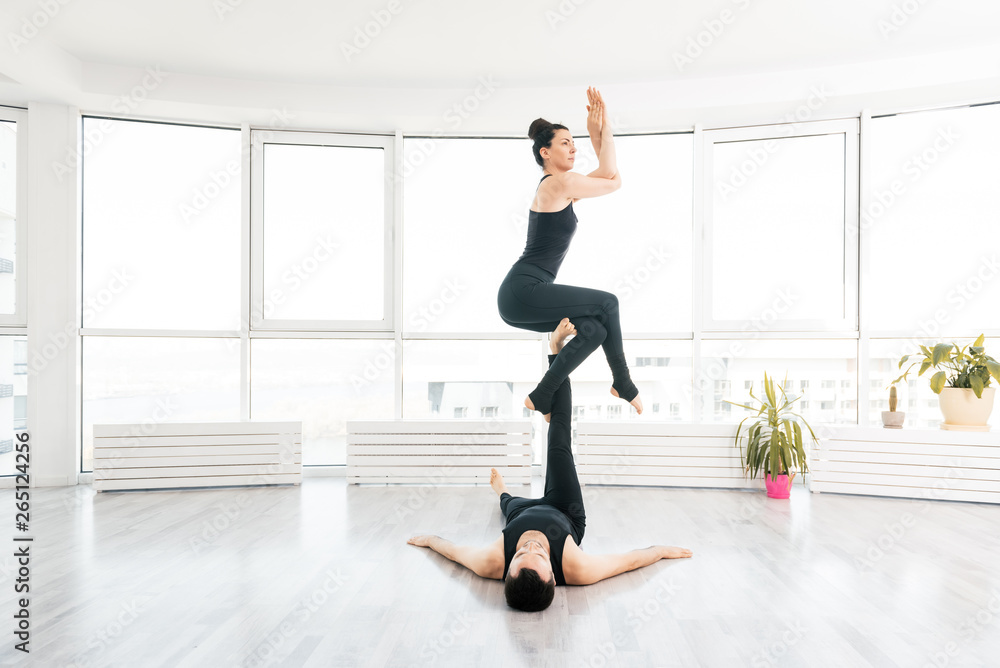 Young couple doing acro yoga in pair at studio Young couple doing acro yoga in pair at studio