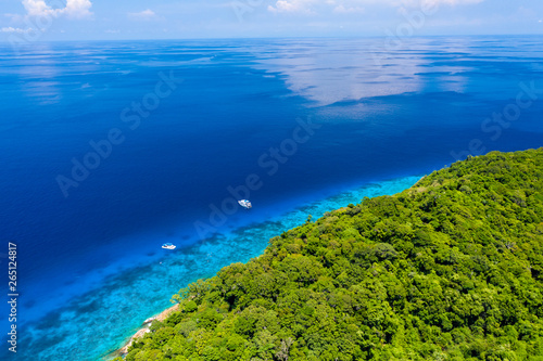 Aerial drone view of boats and coral reef around beautiful tropical islands in a warm ocean