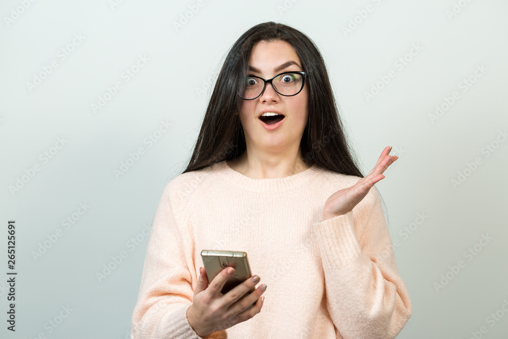 Young beautiful woman using mobile phone studio on white color background. Looking attentively at screen of cellphone, browsing web pages. Young beautiful woman using mobile phone studio on white color background. Looking attentively at screen of cellphone, browsing web pages.