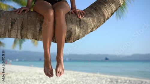 Woman sitting on palm tree.