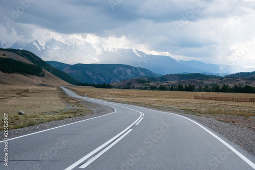 Asphalt winding road in the mountainous area Altai in the summer and sky with clouds