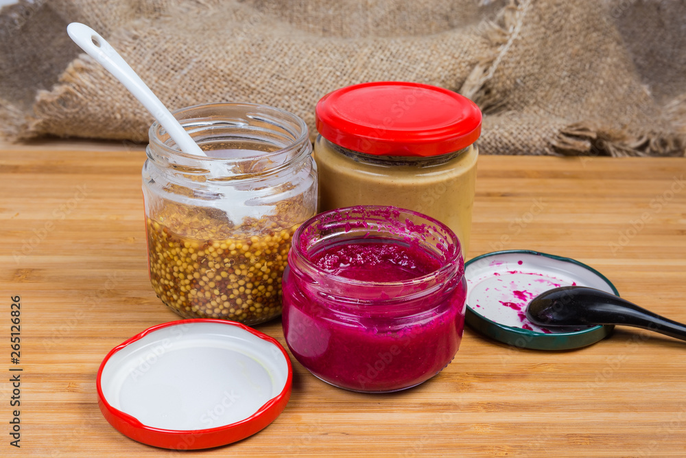 Traditional mustard, French mustard and horseradish sauce in small jars Traditional mustard, French mustard and horseradish sauce in small jars