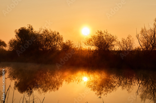 sunrise on the lake , the glare of the sun on the water