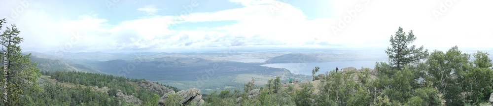 panoramic view from the top of the mountain to the mountain expanses with a lake