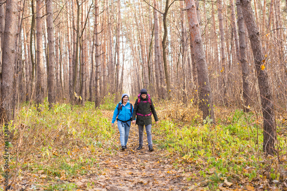 People, hike, tourism and nature concept - Couple tourist hiking in autumn forest People, hike, tourism and nature concept - Couple tourist hiking in autumn forest