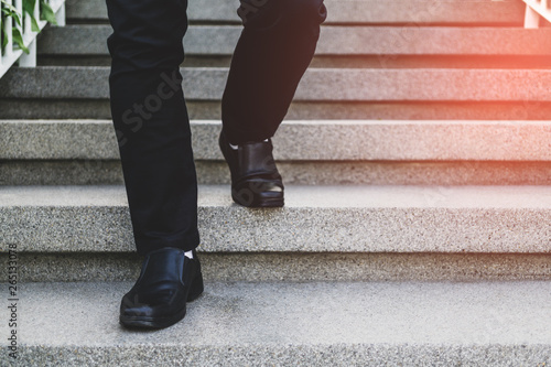 Businessman legs walking up the stairs