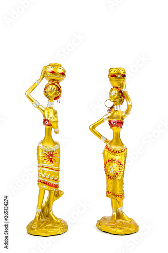 Gypsum figures two Indian girls with yellow color in traditional costumes with pitchers on their heads, isolated on white background