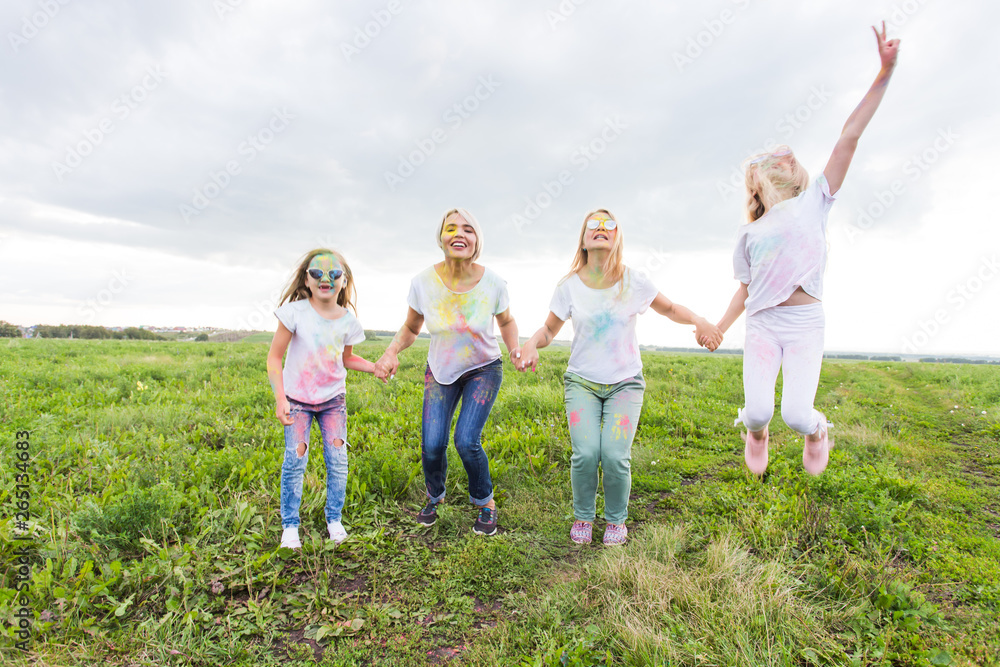 Festival of Holi, friendship and holidays concept - young female people on the color dancing and having fun Festival of Holi, friendship and holidays concept - young female people on the color dancing and having fun