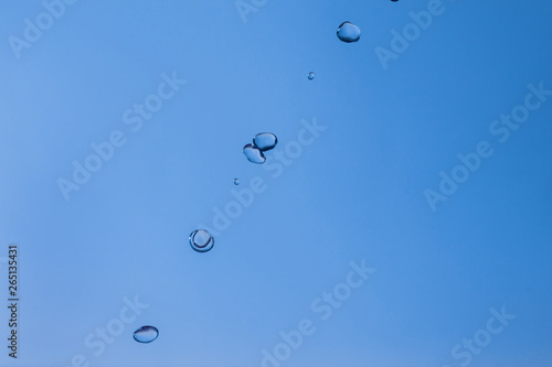 Water bubbles in the blue sky. Water drops on blue background. Aqua, rain, weather, clear. Life, freedom, ease. photo